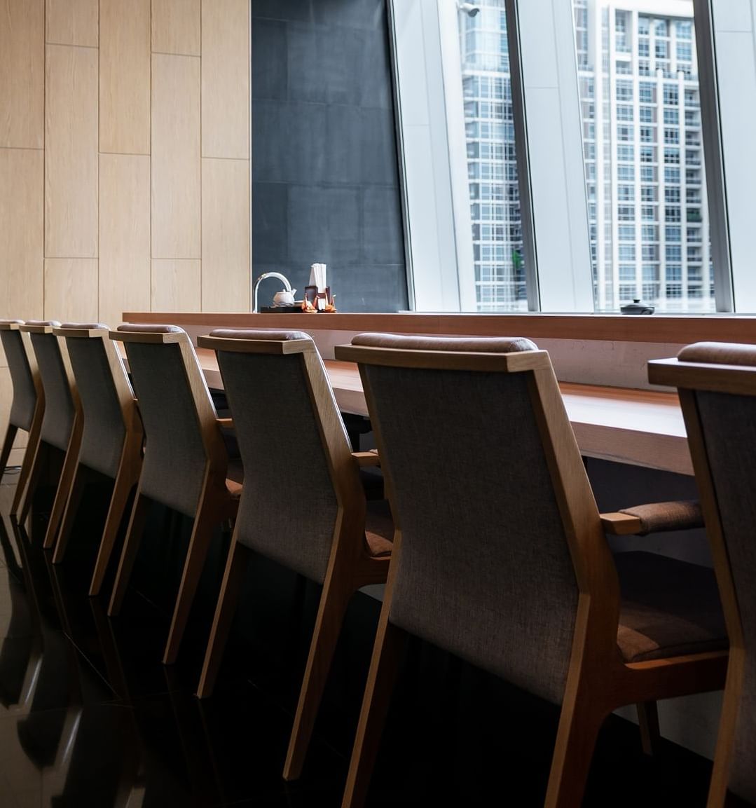 A long table with chairs with a city view at Okura Prestige