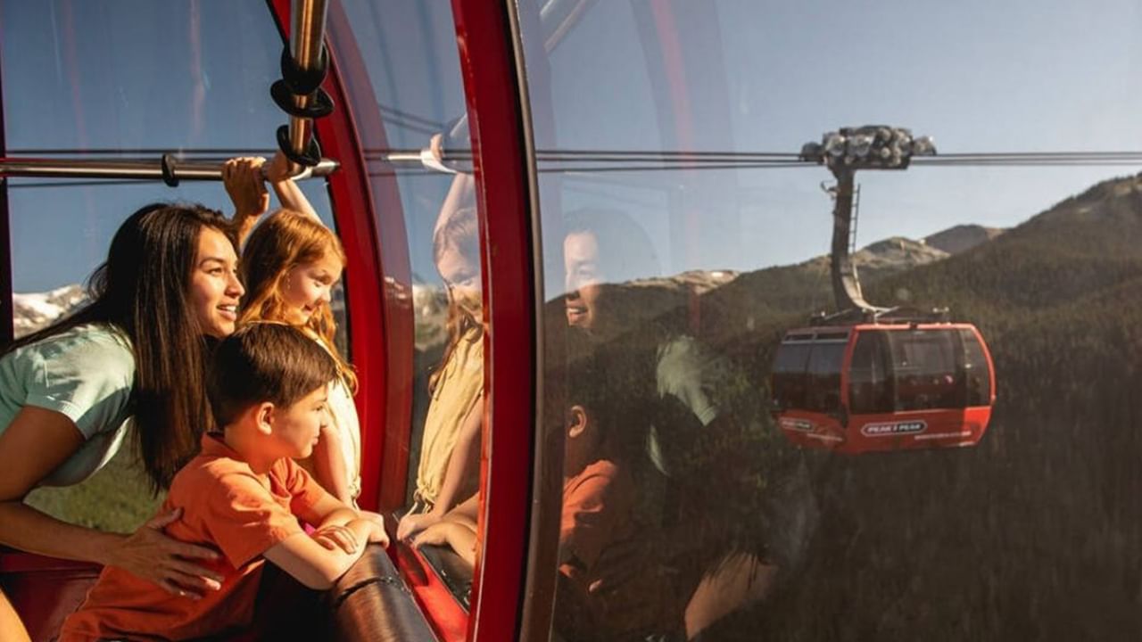 Family riding a gondola with mountain views in Whistler