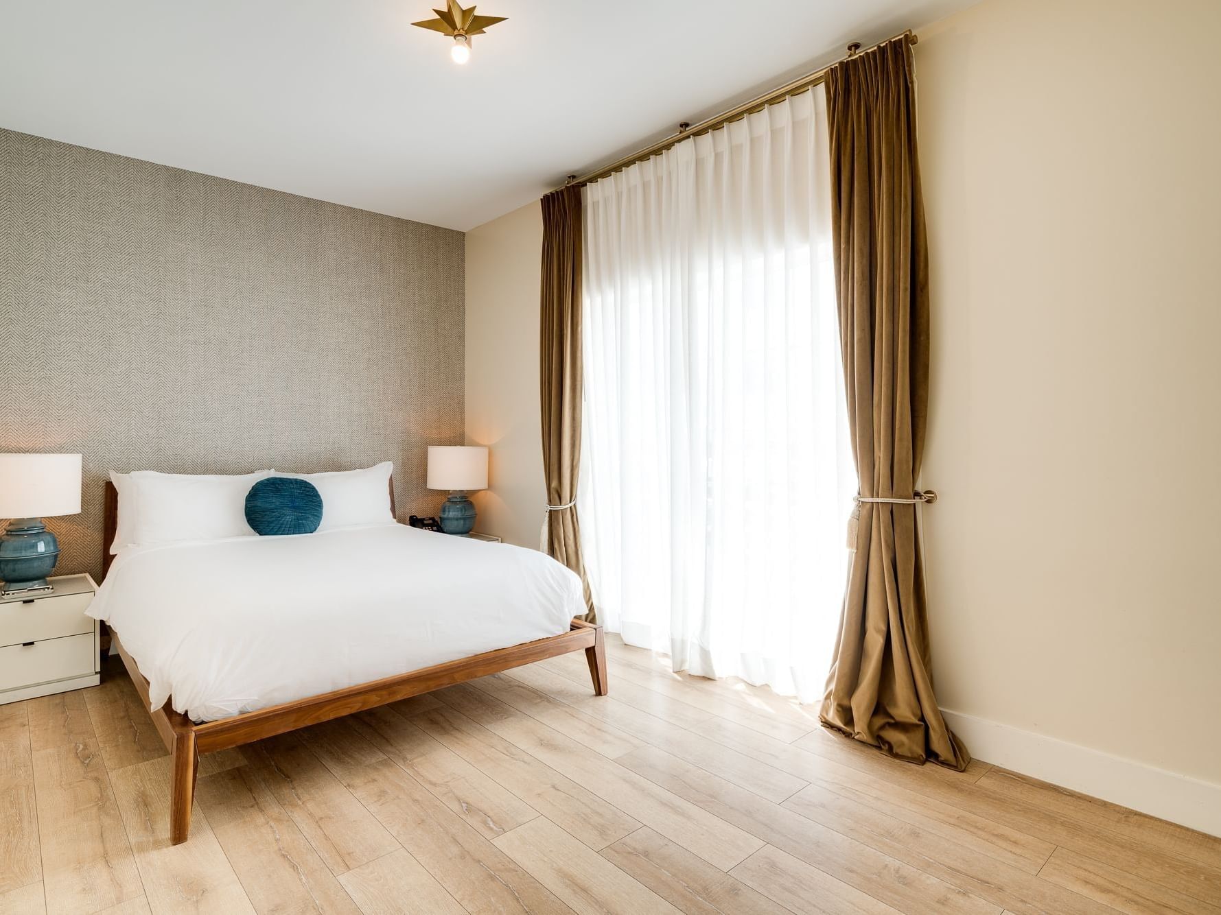 Two Bedroom Suite Queen with cozy bed & side tables with lamps at The Savoy Hotel & Beach Club