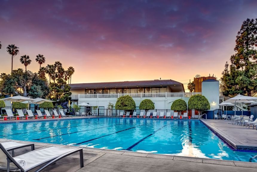 Outdoor swimming pool area at The Anaheim Hotel at sunset