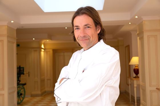 A chef posing in a hallway at Hotel Liebes Rot Flueh