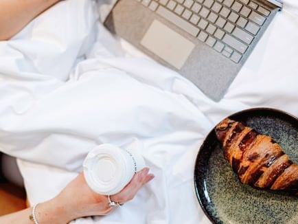 Top view of lady working on the laptop while having breakfast at Brady Hotels Central Melbourne