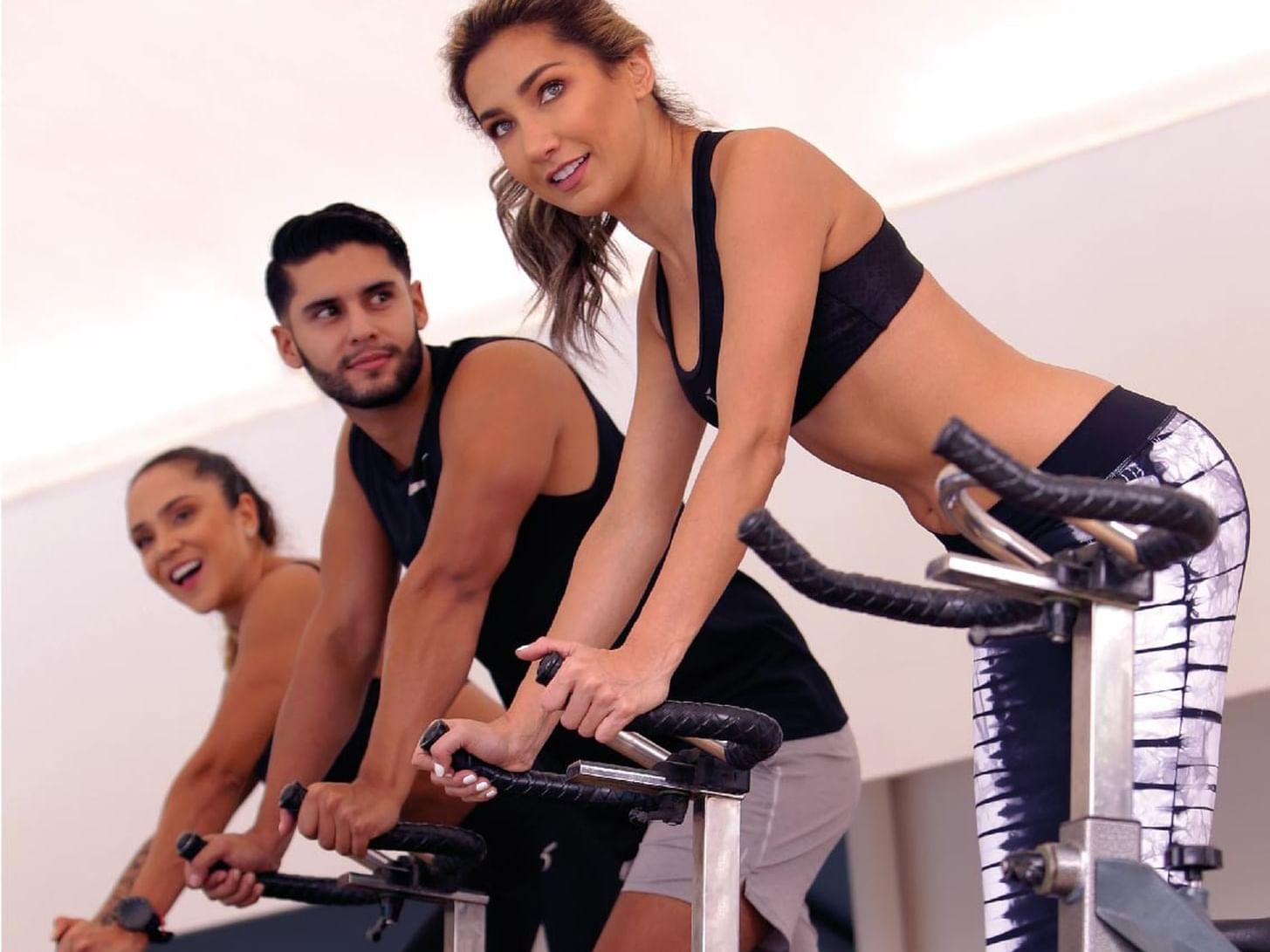 Three people exercising on stationary bikes in the Gym at Hotel Dann Carlton Medellin