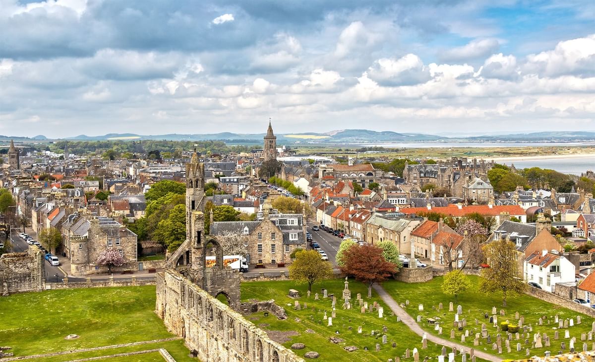 Aerial view of a St Andrews Cathedral with ruins and a cemetery, overlooking a bay near Seaton House