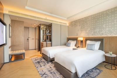 Two comfy beds, lamps & TV in Superior Room at Eastin Hotels