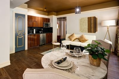 Stylish living room at Riviera Hotel South Beach with a marble dining table, white sofa, and modern kitchenette