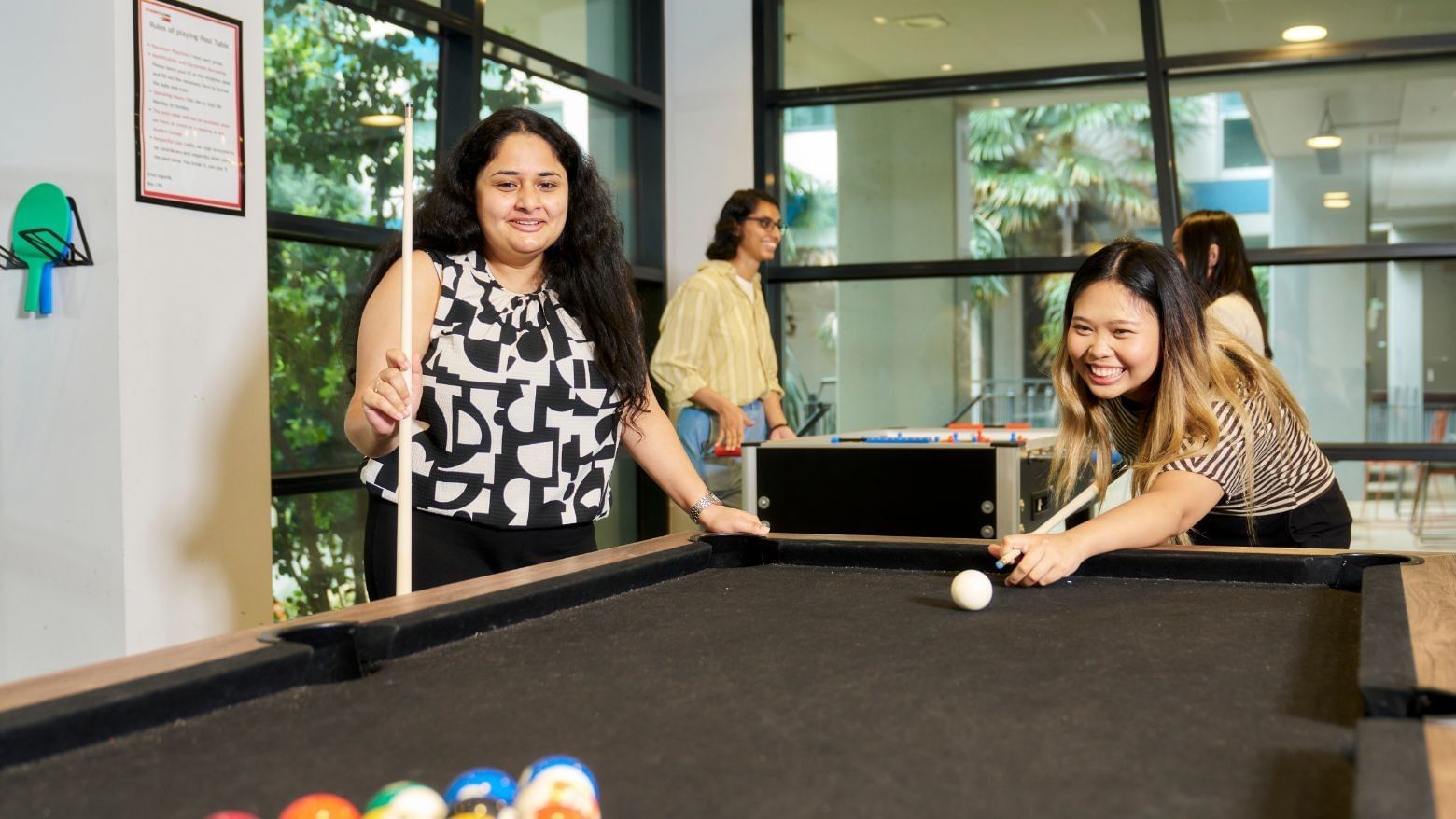 Two residents playing pool at Student Living - 800 Swanston.