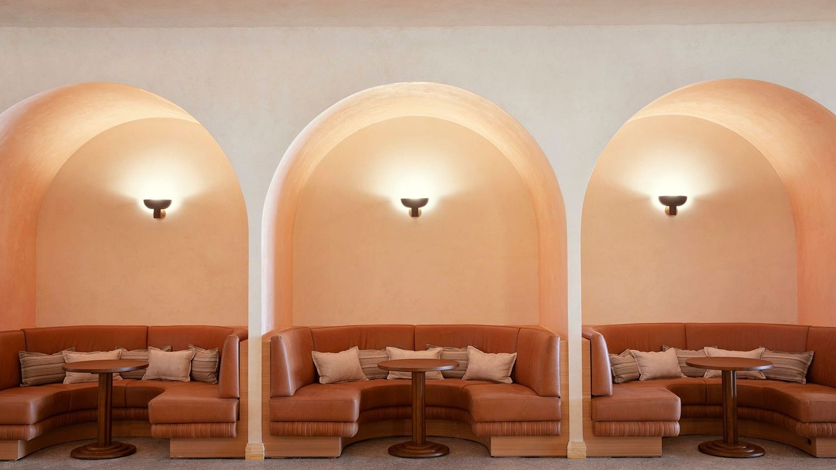Cibaria\'s 55 North Bar at Elysium Manly with leather booths around tables under arched alcoves surrounding a carpeted floor