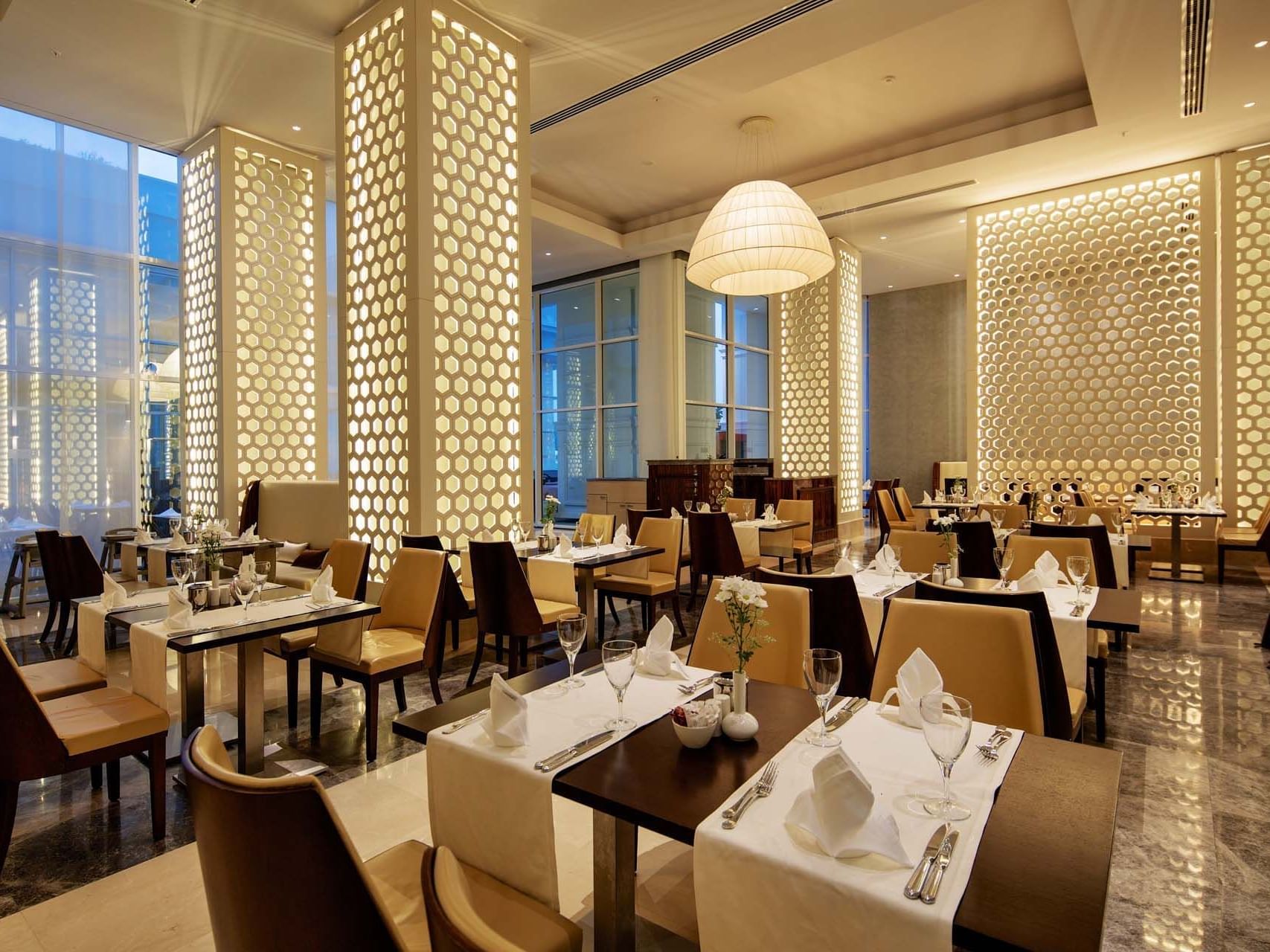 Dining tables with patterned partitions in a restaurant at Titanic Deluxe Golf Belek