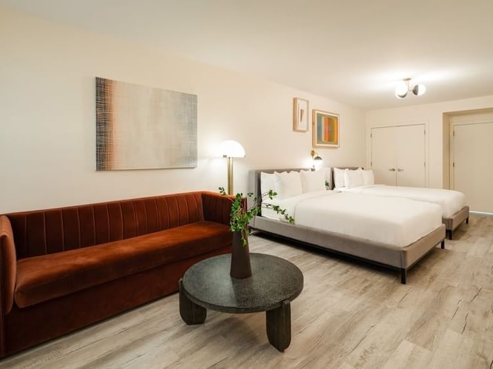 Deluxe Double Queen with two comfortable beds and a stylish rust-velvet sofa in South Beach hotels at Kenmore Village Hotel