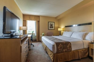 king size bed and a television in monte carlo inns hotel room Markham