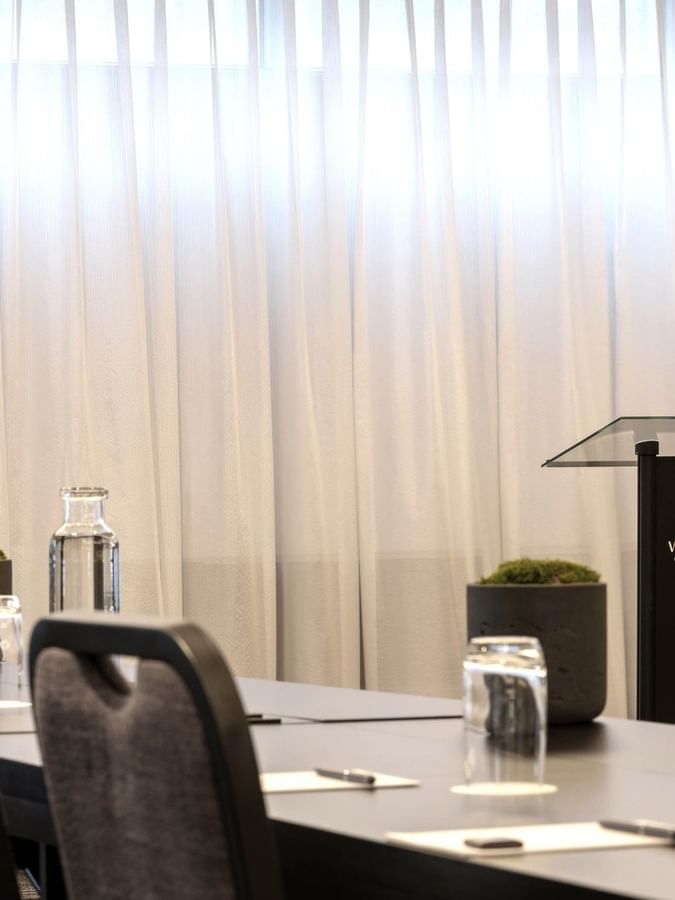 Black lectern with hotel branding by table settings in Salon René-Lévesque at Warwick Le Crystal Montreal