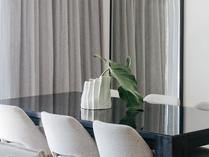 Coastal Two Bedroom Suite at Elysium Manly with a glossy dining table by a ceramic vase, offering cozy Manly accommodation