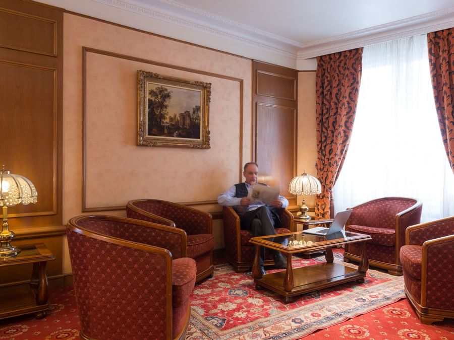 A man seated in the living area at Hotel Paix Republique