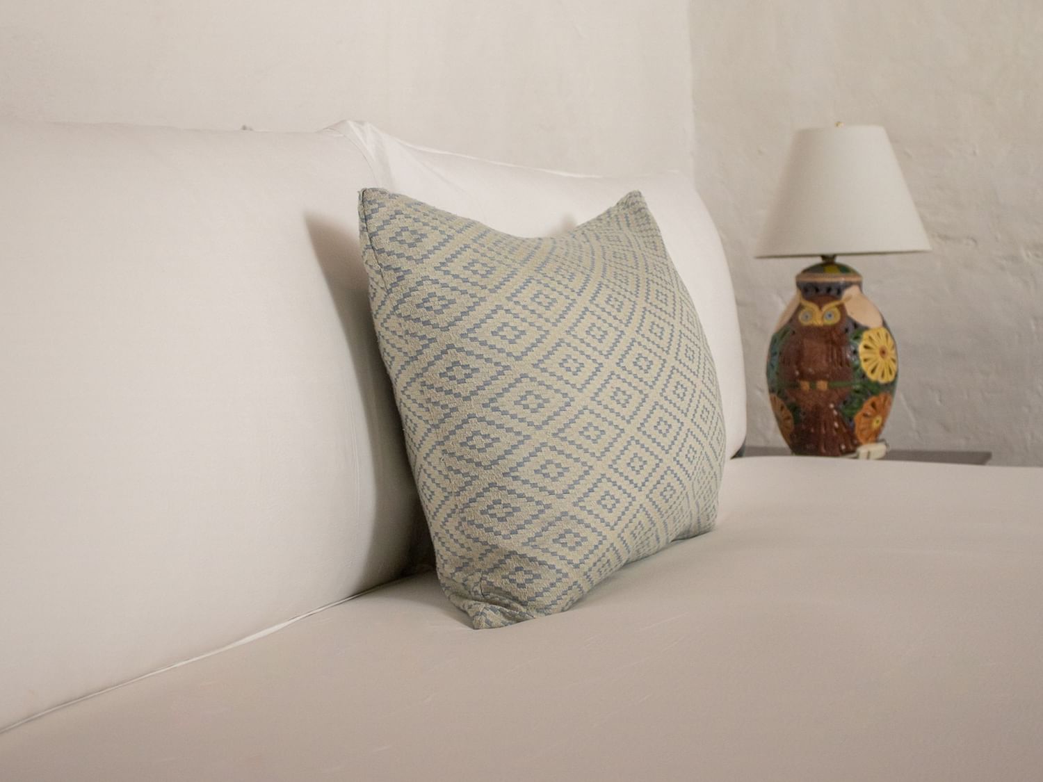 Cama con almohadas y lámpara en Suite Gobernador King de Quinta Real Oaxaca en Oaxaca de Juárez