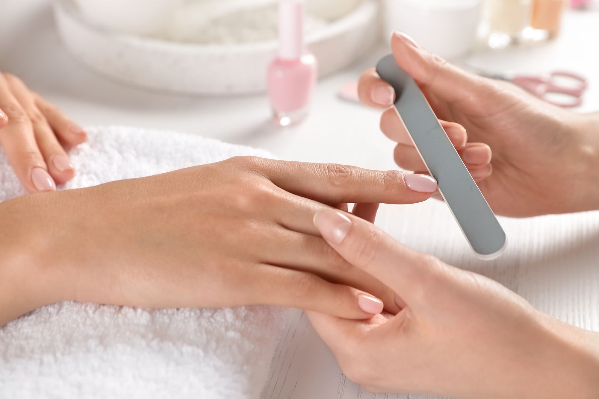Manicure session showing a hand receiving nail care treatment at Warwick Melrose Dallas