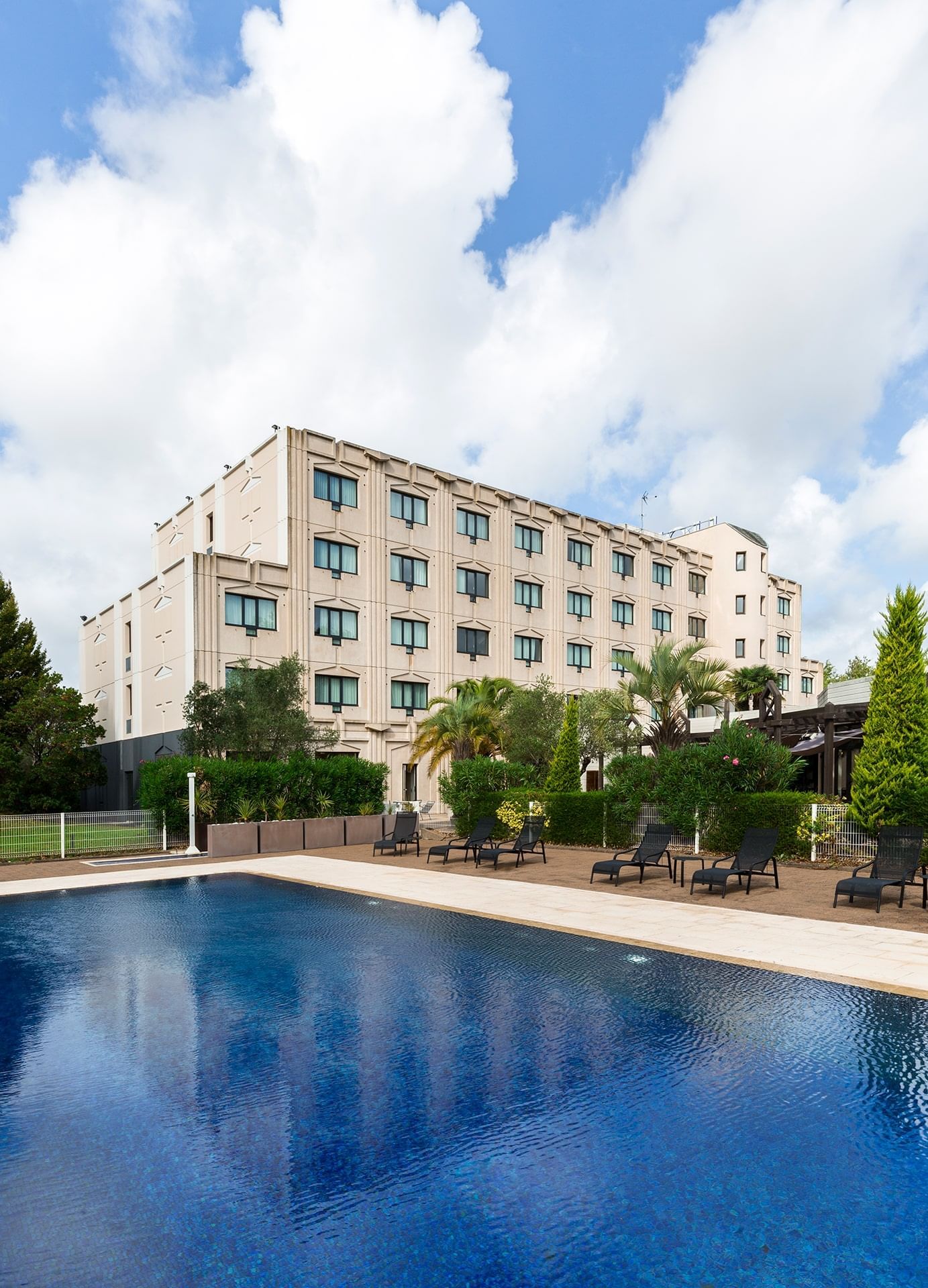 Lounges by the outdoor pool area at Oceania Nantes Aéroport