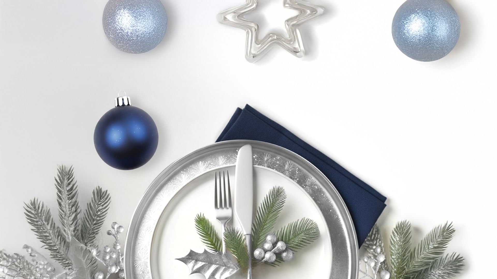 A festive Christmas Eve Dinner plate set with a knife, fork, and silver decor.