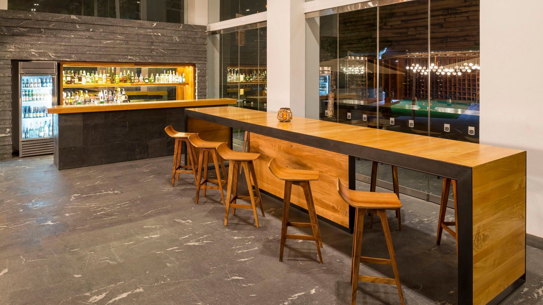 Blue Bar with a long wooden counter and sleek designer stools at Camino Real Puebla Angelopolis