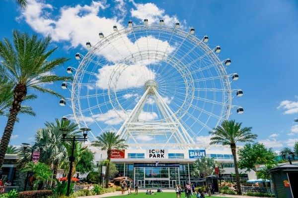 Palm trees and blue skies surrounded The Orlando Eye observation wheel near Rosen Inn International, a budget-friendly hotel near ICON Park in Orlando.