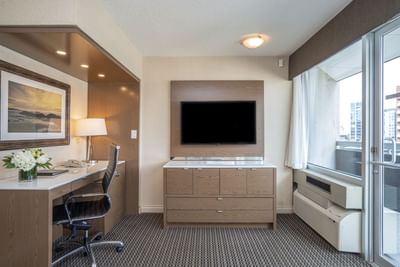 Wall-mounted TV and desk in hotel room