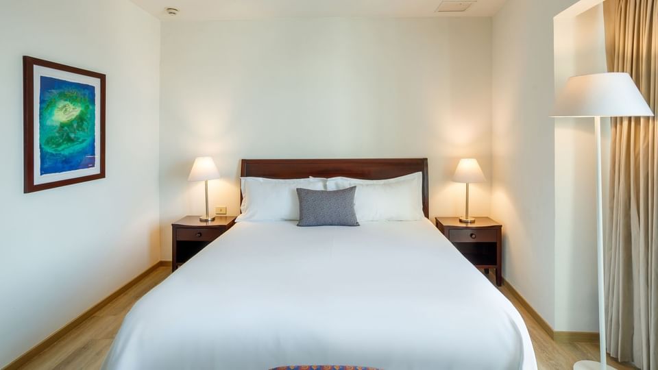 King Junior Suite with a wooden headboard, white linens, and blue wall art at Camino Real Pachuca