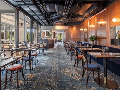 The Reserve Restaurant with wooden paneling, elegant lighting, and floor-to-ceiling windows at Amora Herencia Riverwalk