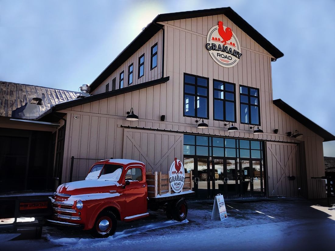 A red truck parked in front of Granary Road Farmers Market near Hotel Clique Calgary Airport