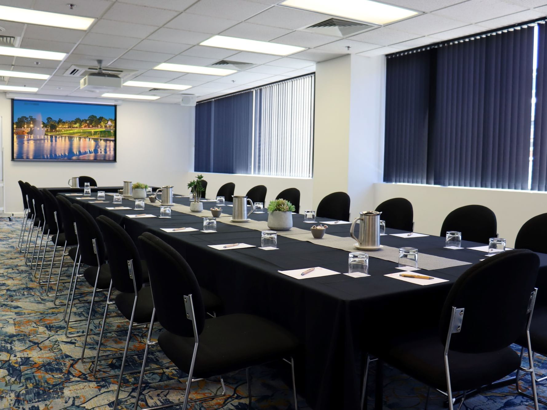 TV screen by the boardroom table in West End Room 1 at Hotel Grand Chancellor