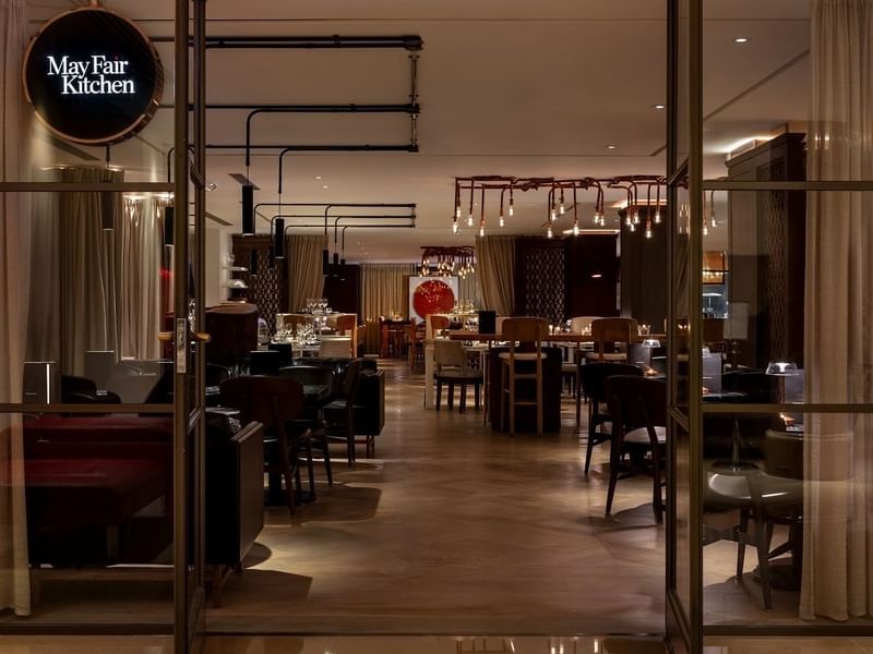 Modern dining room at The May Fair Kitchen at The May Fair Hotel in London, with stylish furnishings and a welcoming atmosphere.