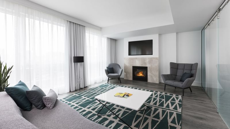 Living space with fireplace and comfy chairs in Penthouse Crescent at Warwick Le Crystal
