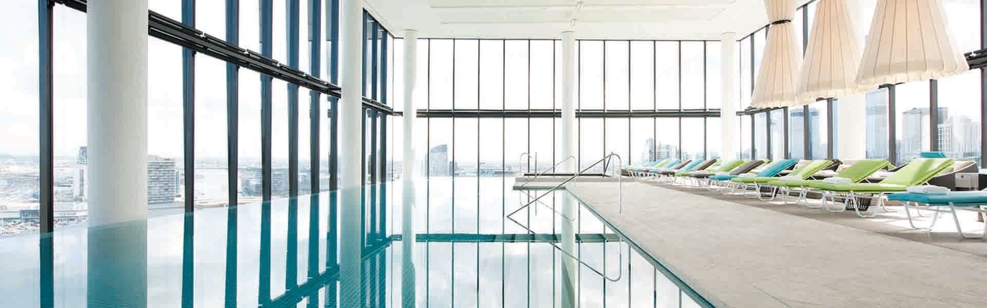 Indoor pool with lounge chairs at Crown Hotels