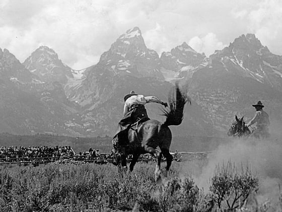 Two men on horses by the mountains near Hotel Jackson