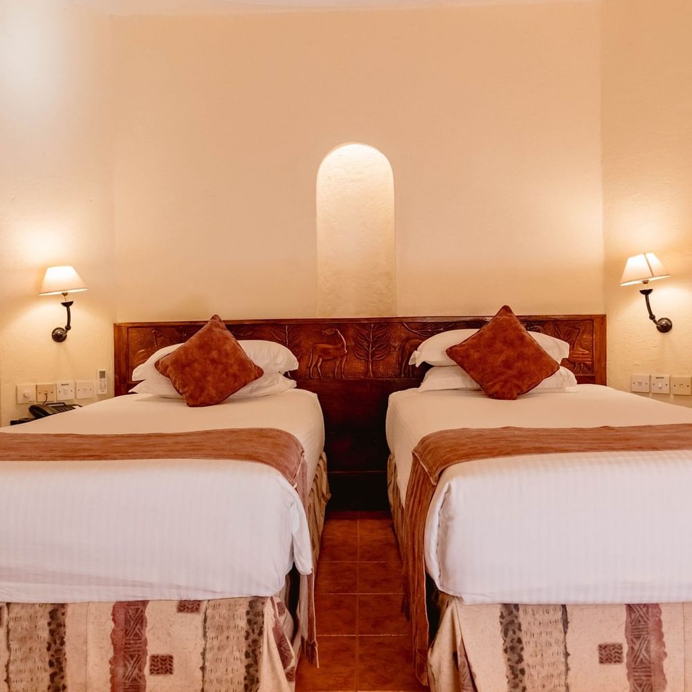 Standard Twin Room with two beds and patterned bedding at Arusha Serena Hotel.