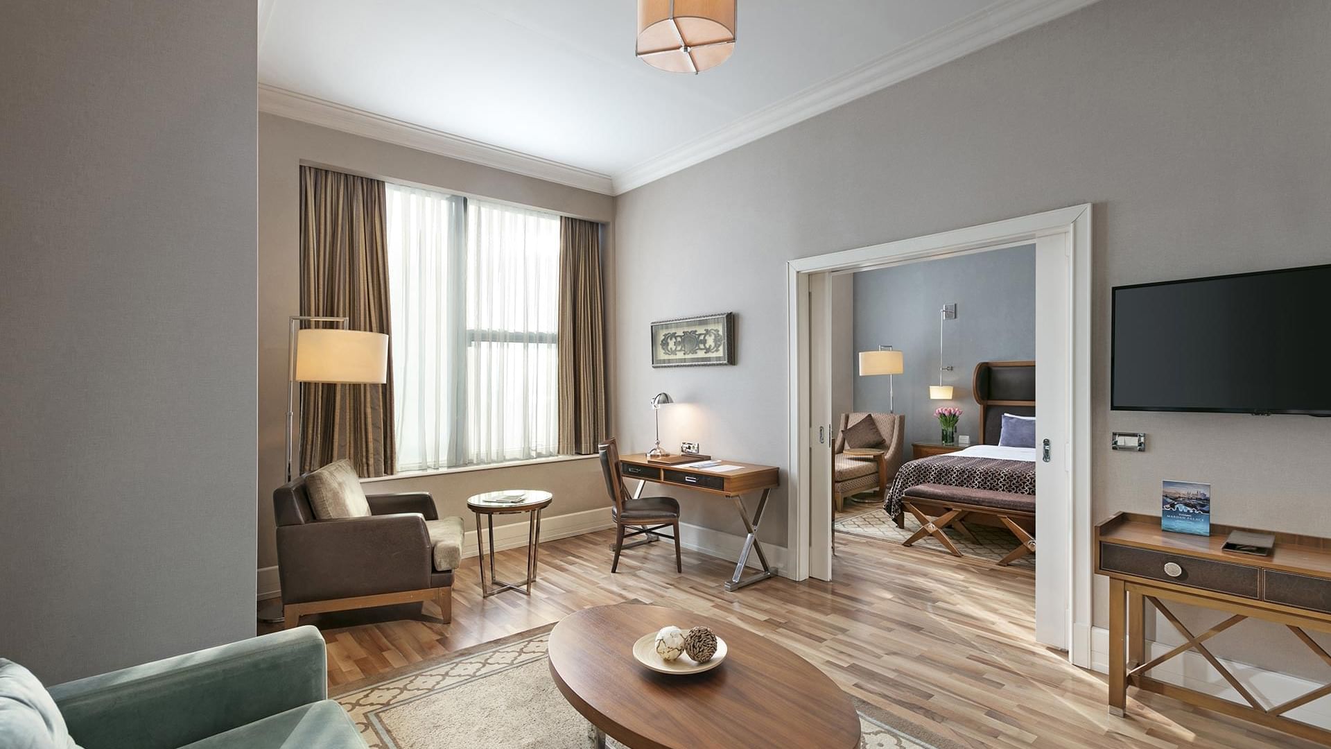 Titanic Business Kartal'daki Premier Suite'in oturma alanında, çalışma masasıyla birlikte konforlu koltuklar düzenlenmiştir.