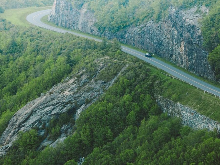 Aerial view of a winding road through mountains of Blue Ridge Parkway near The Embers Hotel