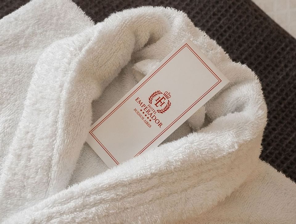 A white bathrobe with the tag of Hotel Emperador Buenos Aires