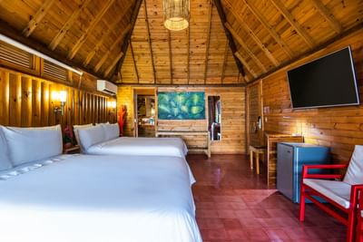 Double beds with TV and room amenities in Junior Suite at Hotel Isla Del Encanto