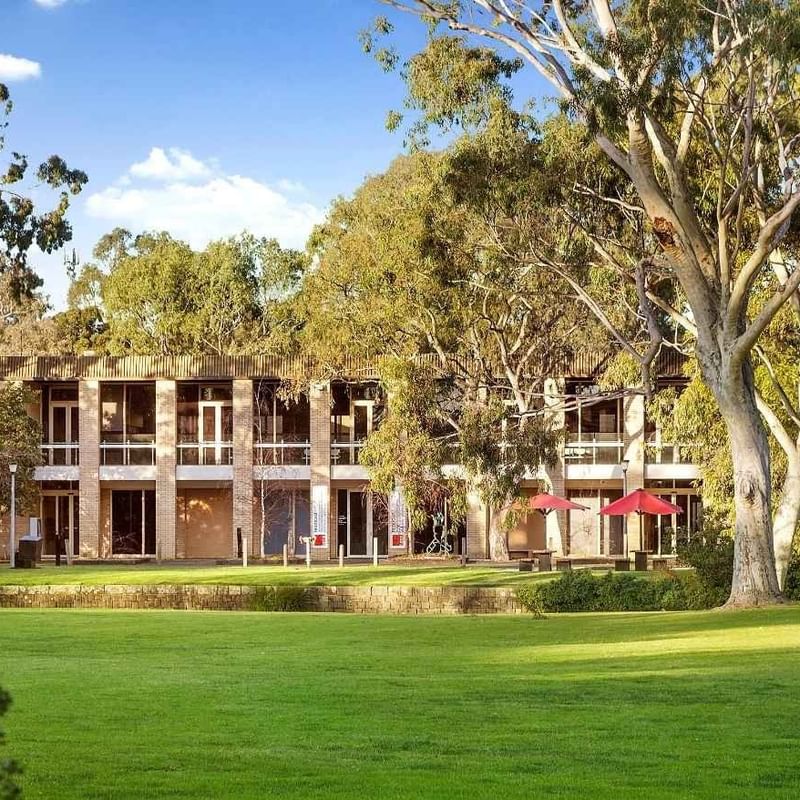 La Trobe University - Glenn College building with lush green lawn and trees.
