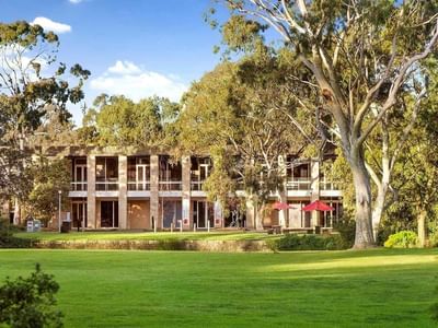 La Trobe University - Glenn College building with lush green lawn and trees.