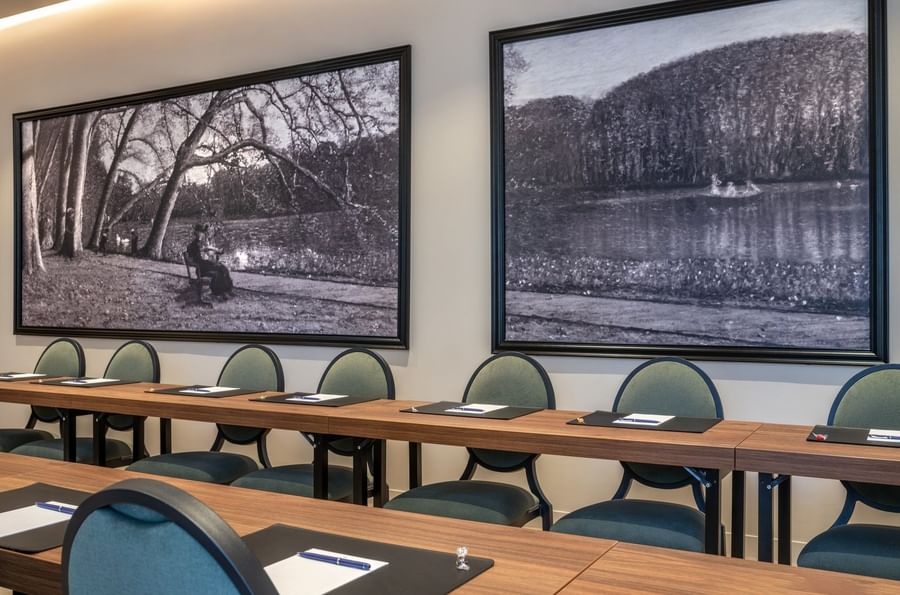 U-shaped table with cushioned chairs and black & white landscape art in Windsor meeting room at Warwick Reine Astrid - Lyon