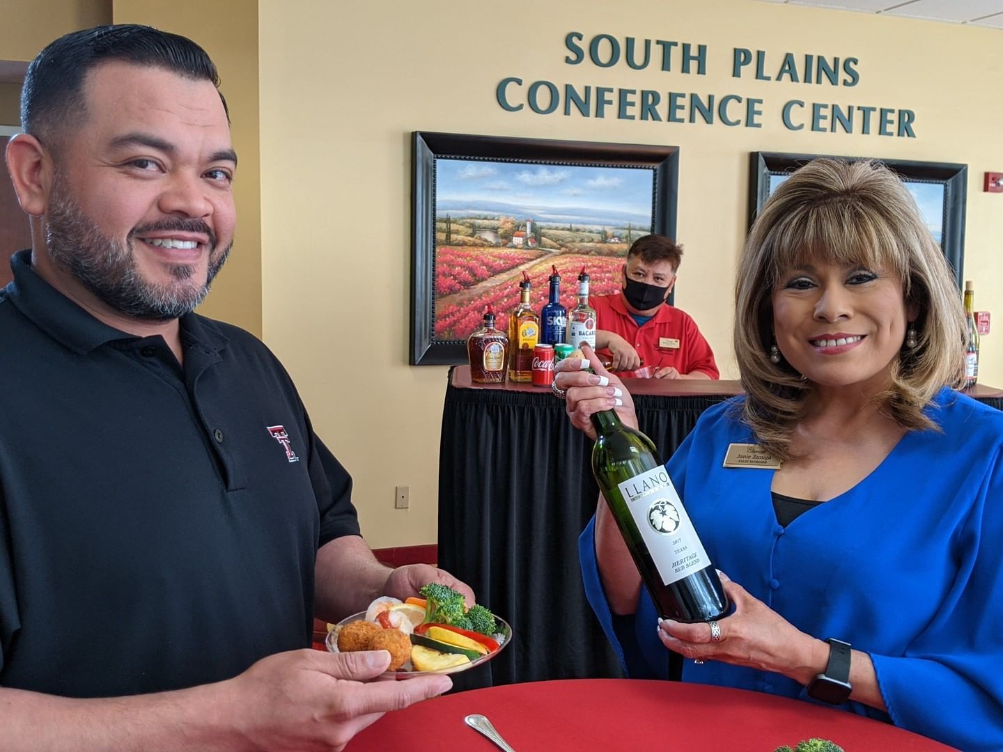Lady with a wine bottle & a man with some snacks at MCM Hotel