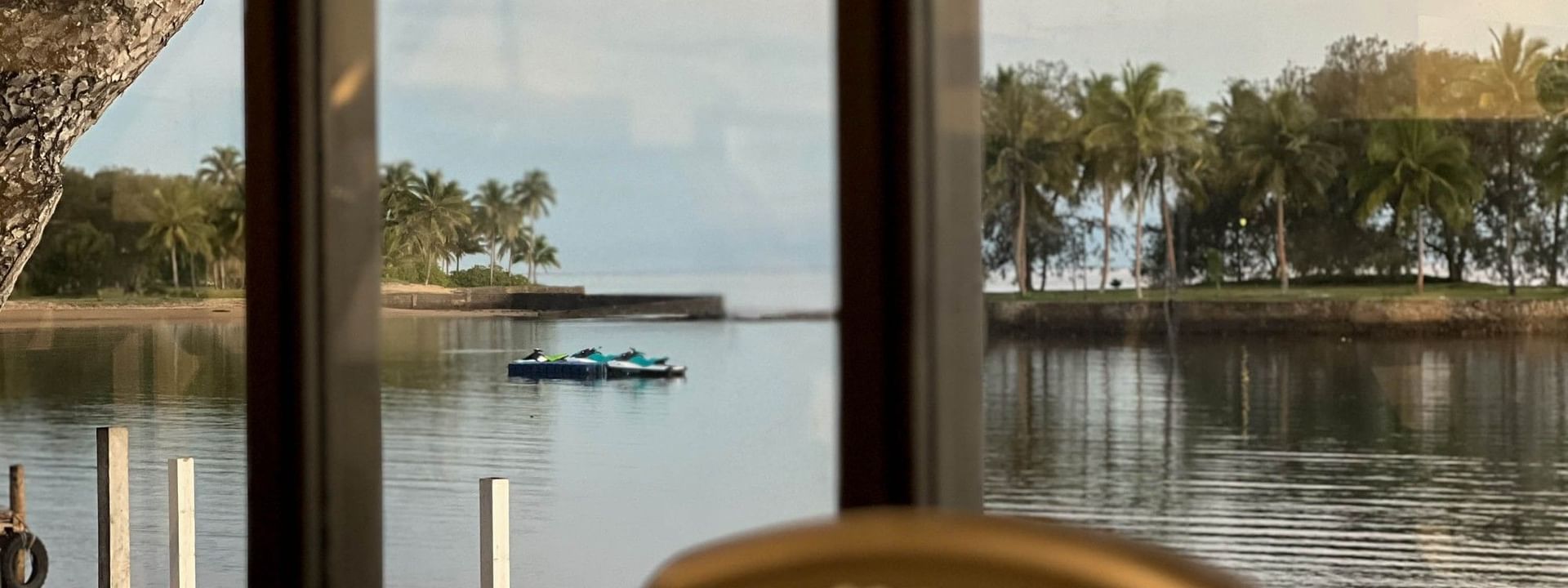 Gym equipment by a view of palm trees and water under pink clouds at The Naviti Resort in Korolevu