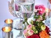 Wedding table centerpiece with a glass candle holder, floral arrangements, and silver votive candles at The Sebel Brisbane