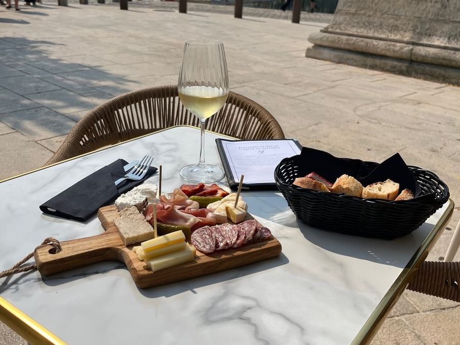 Table en plein air avec charcuterie et vin blanc au Yachtman.