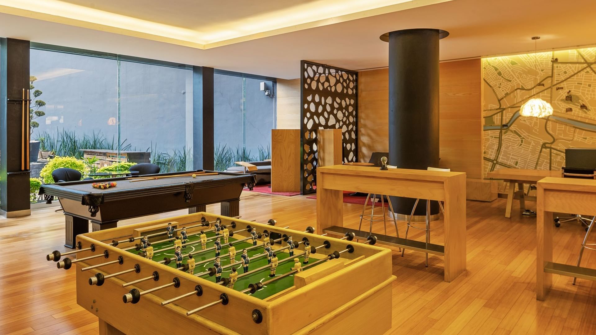 Game room featuring a foosball table, billiards, modern decor, and large windows at Fiesta Inn Monterrey Valle