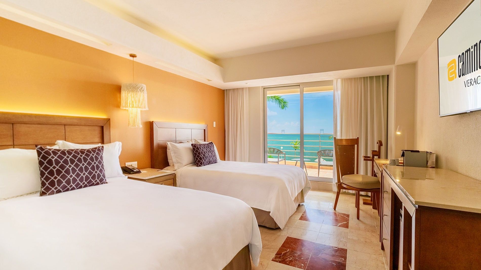 2 Double Camino Real Club featuring white linens, orange walls, and a sunny ocean balcony at Camino Real Veracruz