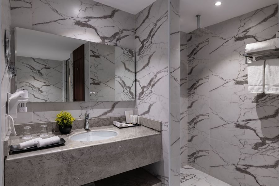 Deluxe Room bathroom featuring a marble vanity & a shower rack at Warwick Al Taif Hotel