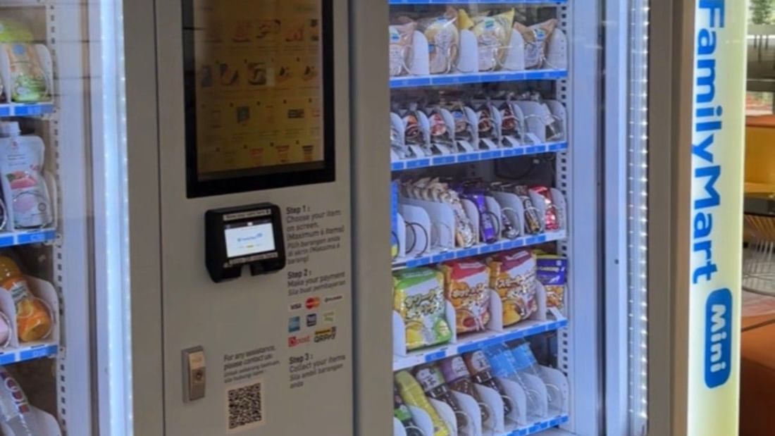 FamilyMart Mini vending machine with digital display, payment options, and various packaged items inside.