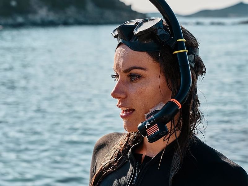 Female diver with snorkels in the sea near Falkensteiner Hotels